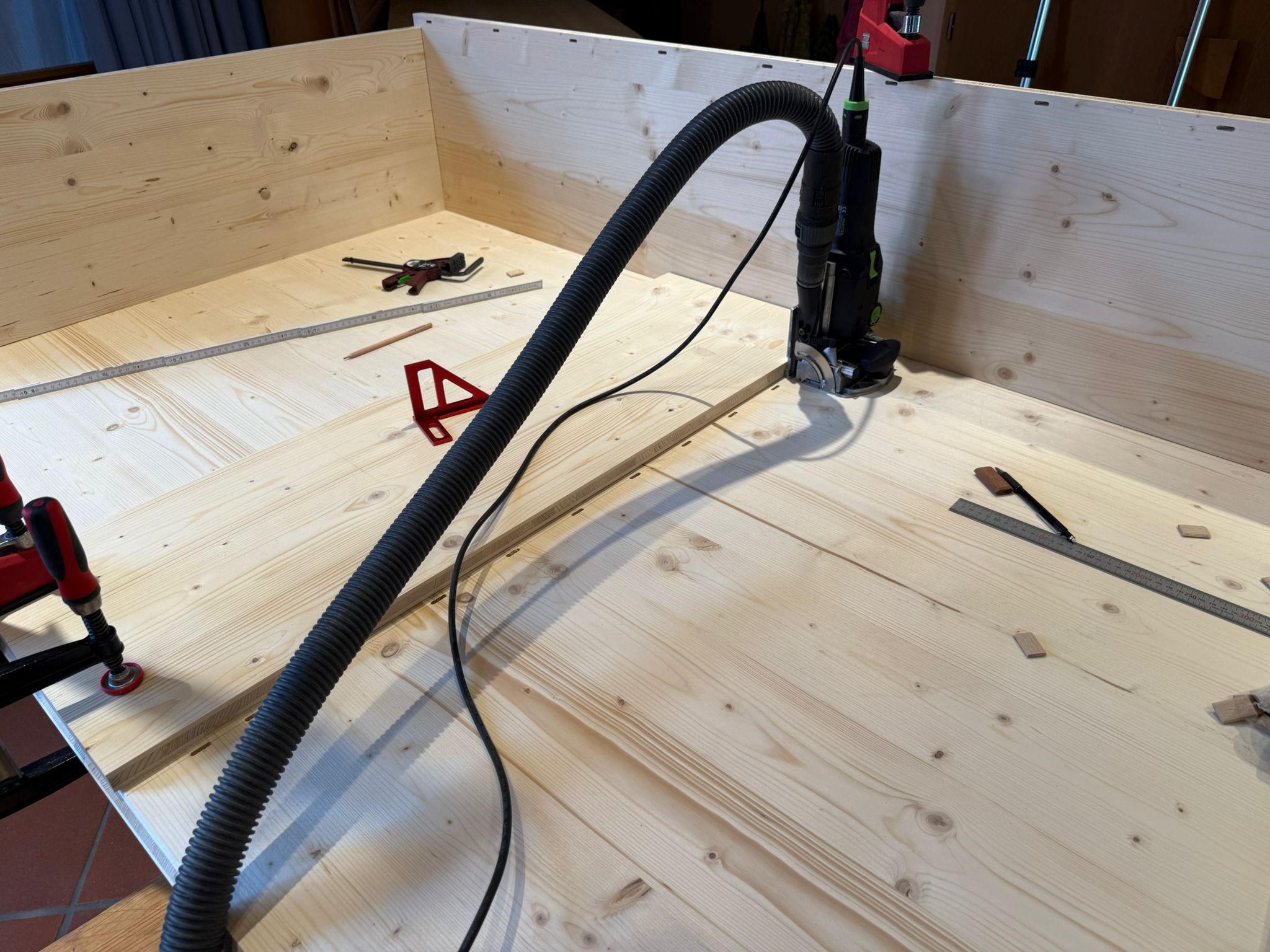 Holzwerkstatt mit Werkbank, Werkzeugen und einem langen Bauteil